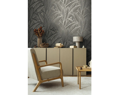 Wohnzimmer mit gemusterter Tapete, Sessel, Sideboard und Dekoration