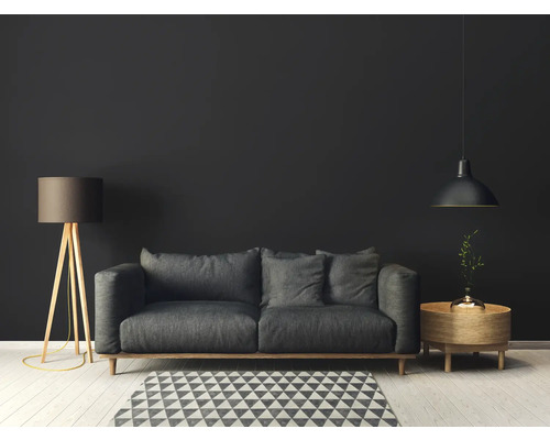 Wohnzimmer mit grauem Sofa, Stehlampe, Pendelleuchte und Teppich