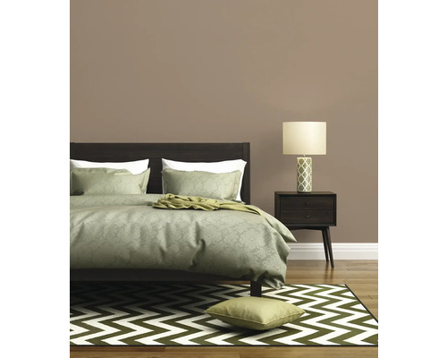 Schlafzimmer mit Bett, Nachttisch und Teppich im Zickzackmuster