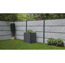 Gartenszene mit Sichtschutzzaun, Pflanzkasten und Grünpflanzen auf Rasen