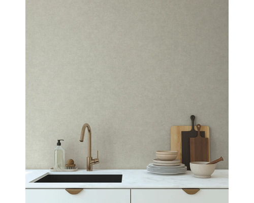 Küchenspüle mit Armatur und Geschirr vor einer hellen Wand