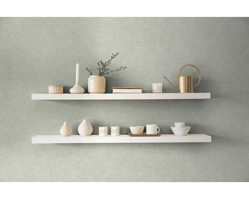 Zwei weisse Regale an einer Wand dekoriert mit Vasen, einer Kerze, einer Giesskanne und Geschirr