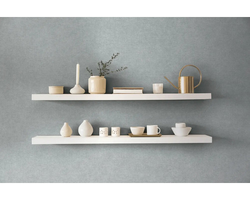 Zwei weiße Regale mit Dekorationsartikeln an einer Wand
