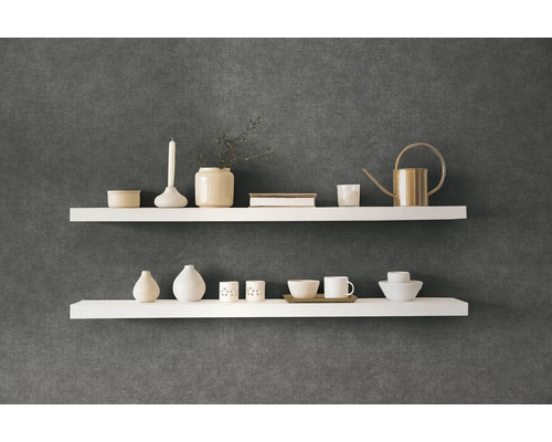 Zwei weiße Wandregale mit Dekorationsartikeln an einer dunklen Wand
