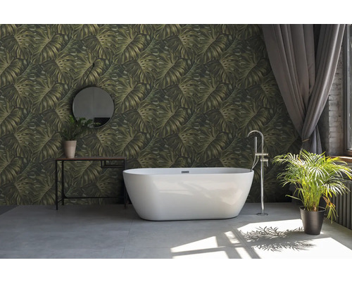 Badezimmer mit freistehender Badewanne, Konsole mit Spiegel und Zimmerpflanzen vor einer Wand mit Blättermuster-Tapete.