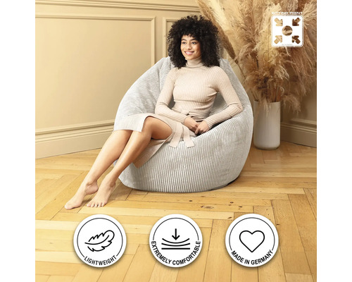 Frau sitzt in einem hellen, gerippten Cord Sitzsack.