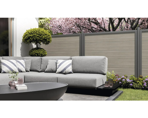 Szene im Garten mit Lounge-Möbeln, Gartenzaun und Dekoration