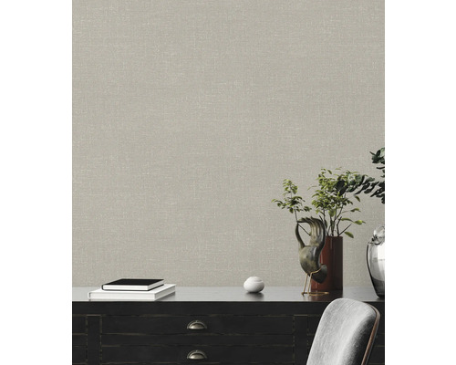 Nahaufnahme einer Wand mit einer beigen Textiltapete, die über einem Sideboard angebracht ist.