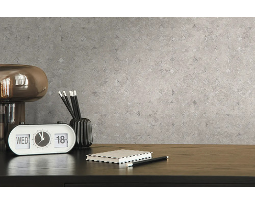 Nahaufnahme einer grauen Mustertapete mit einem Schreibtisch und Accessoires