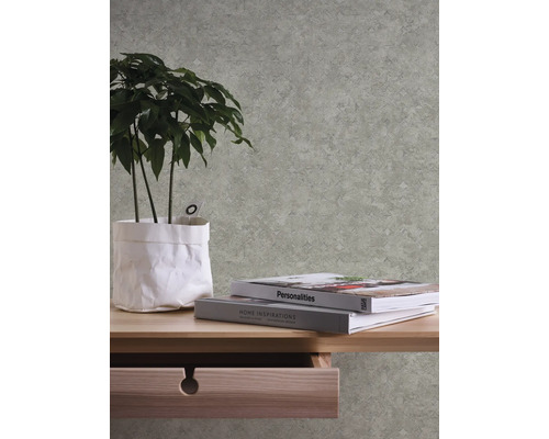 Helle Tapete mit geometrischem Muster in einem Raum mit Tisch und Pflanze.