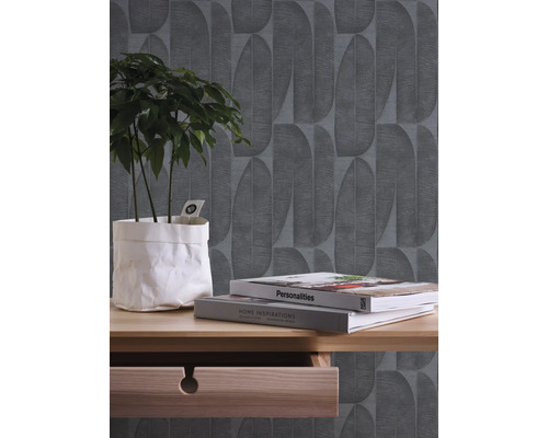 Szene mit gemusterten Tapeten, Pflanze und Dekorationsbüchern auf einem Holztisch