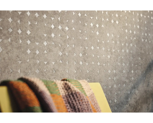 Nahaufnahme einer grauen Vliestapete mit kreisförmigem Muster und Ausschnitten