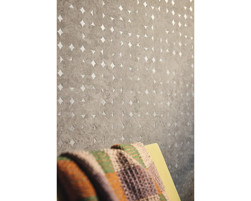 Graue Tapete mit Kreismuster und Sternausschnitten an einer Wand.