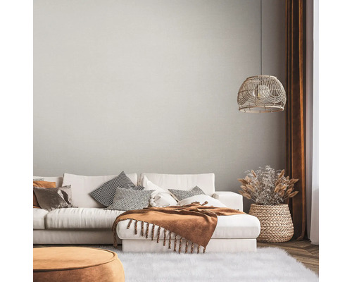 Wohnzimmer mit Sofa, Kissen, Decke, Lampe und Dekoration in einem hellen, gemütlichen Stil.