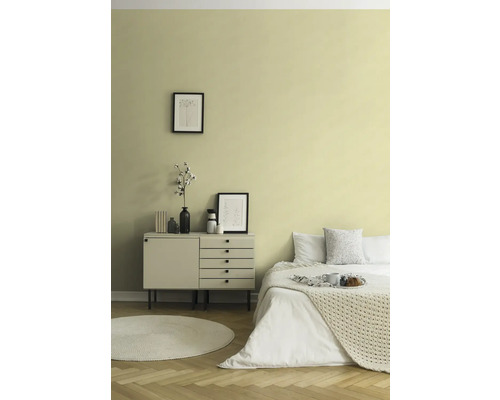 Schlafzimmer mit Bett, Kommode, runder Teppich und Wanddekoration