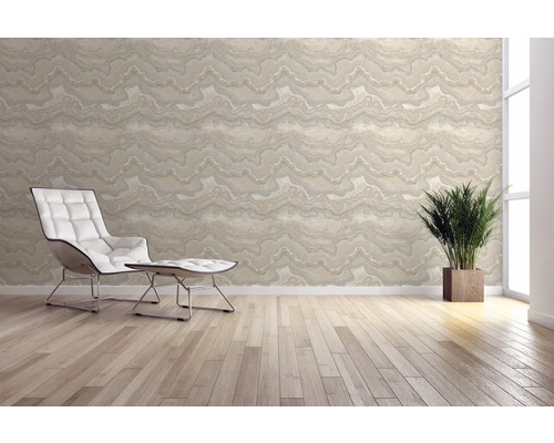 Heller Raum mit gemusterter Tapete, Sessel und Zimmerpflanze