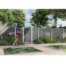 Moderner Sichtschutzzaun aus grauen horizontalen WPC-Lamellen mit passender Gartentür auf einer hellen Holzterrasse im Garten.