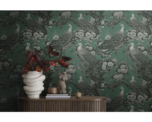 Zimmer mit gemusterter Tapete mit Pfauen und Blumen, dekoriert mit Wohnaccessoires auf einem Holztisch