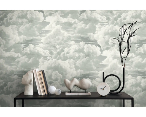 Einrichtungsszene mit Wolken-Tapete, Büchern, Dekorationen und einer Uhr auf einem schwarzen Tisch.