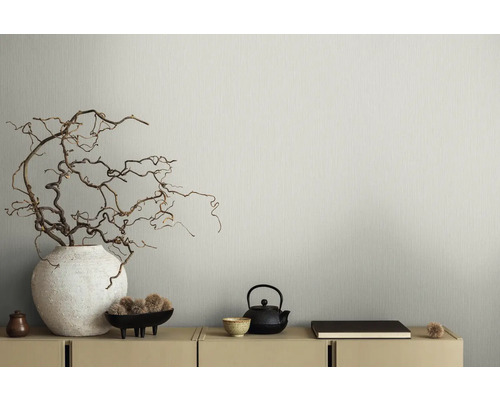 Dekoratives Interieur mit Vase, Ästen, Schale, Teekanne und Buch auf einem Schrank