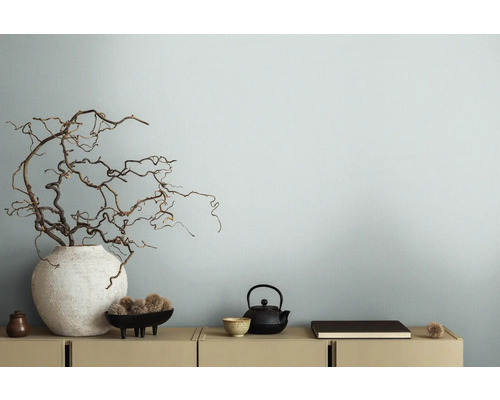 Dekorative Äste in Vase neben Teekanne auf Sideboard