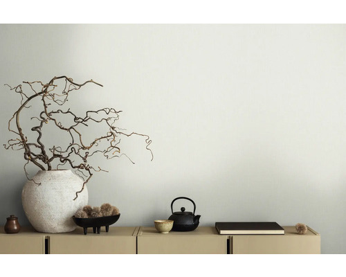 Dekorative Innenraumgestaltung mit Ästen in Vase, Teekanne und Schale auf einem Schrank