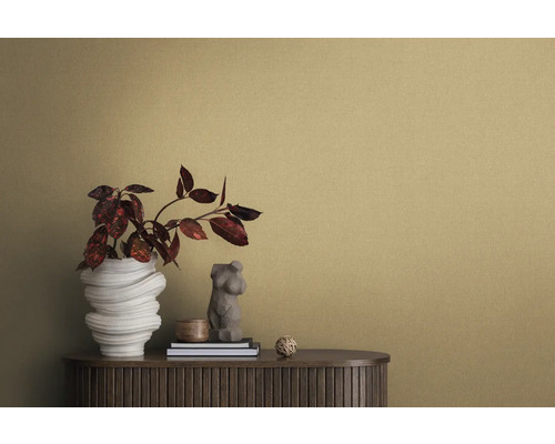 Nahaufnahme eines Raumes mit einer strukturierten Tapete, einem Sideboard, einer Blumenvase und dekorativen Elementen.