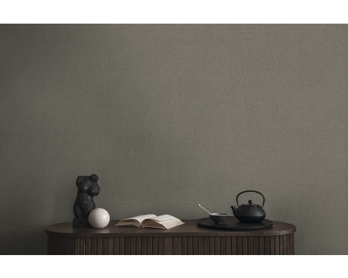 Tapete im Wohnraum mit Tisch, Skulptur, Buch und Teeset