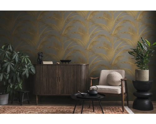 Wohnzimmer mit gemusterter Tapete, Schrank, Sessel, Tisch und Pflanzen