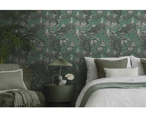 Dekoratives Schlafzimmer mit gemusterter Tapete, Bett, Sessel und Beistelltisch