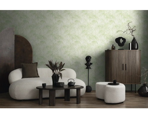 Wohnzimmer mit gemusterter Tapete, Sofa, Hocker und dunklen Holzmöbeln.