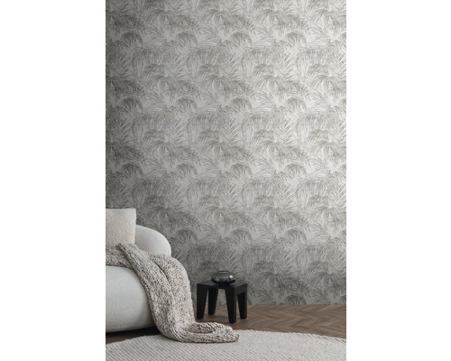 Wohnraum mit Palmenmuster-Tapete, Sessel, Decke und Beistelltisch.