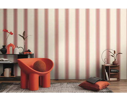 Raumansicht mit gestreifter Tapete, Sessel und dekorativen Elementen auf einem Regal