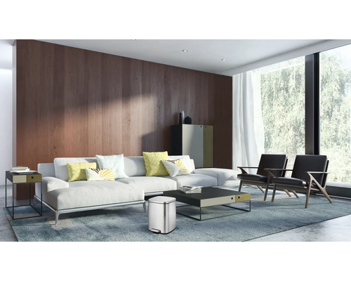 Wohnzimmer mit Sofa, Sessel, Teppich und Abfalleimer