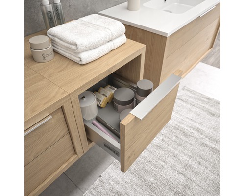 Badezimmer mit Waschtischunterschrank, geöffneter Schublade und Badutensilien