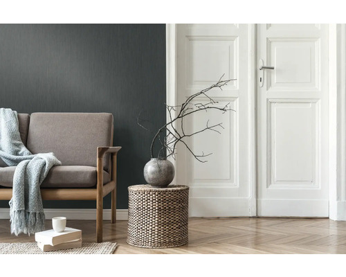 Wohnzimmer mit Sofa, Beistelltisch, Vase mit Ästen und Holzboden