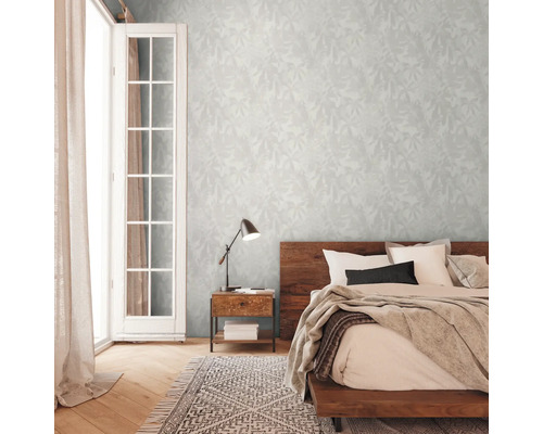 Schlafzimmer mit Doppelbett, Nachttisch, Lampe und gemusterter Tapete