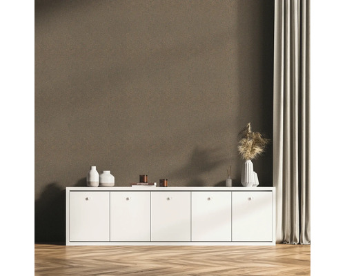 Raumszene mit brauner Vinyltapete mit Muster, weißem Schrank und Dekoration