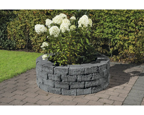 Runde Pflanzmauer aus Betonsteinen mit Hortensienbepflanzung im Garten