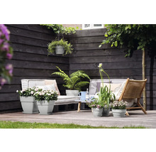 Terrasse mit Gartenmöbeln und bepflanzten Blumentöpfen