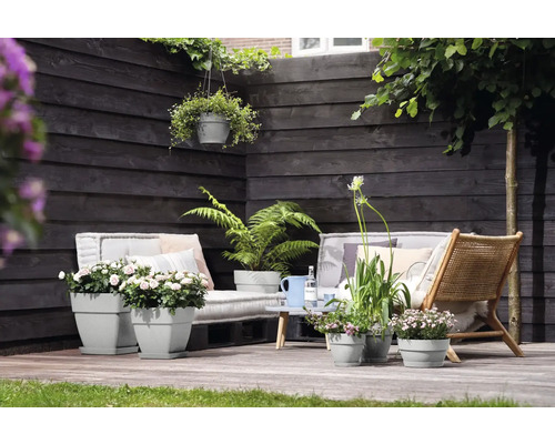 Terrasse mit Gartenmöbeln und bepflanzten Blumentöpfen