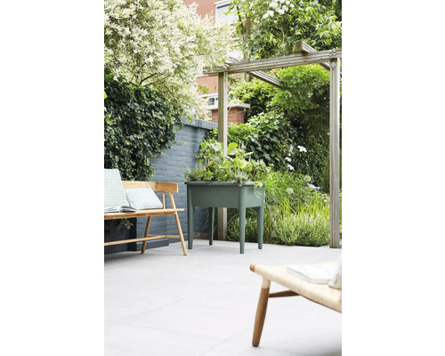 Gartenszene mit Hochbeet, Bänken und Pflanzen