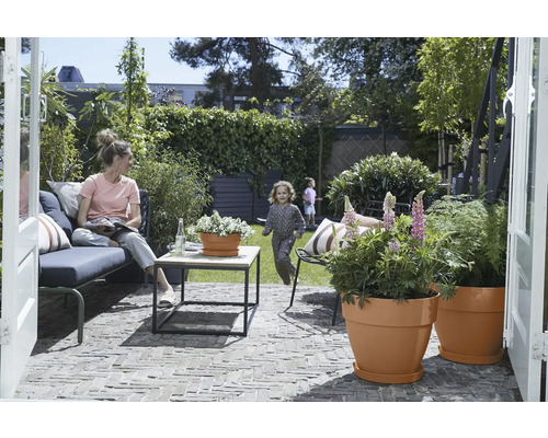 Garten mit Terrasse, Sitzgruppe, Tisch und bepflanzten Blumentöpfen für den Außenbereich