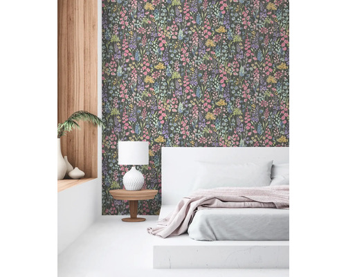 Schlafzimmer mit floral gemusterter Tapete, Bett und Nachttisch mit Lampe