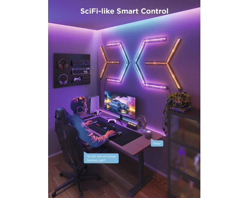 Beleuchtetes Spielezimmer mit Schreibtisch, Computermonitor, Tastatur, Gaming-Stuhl und LED-Wandleuchten