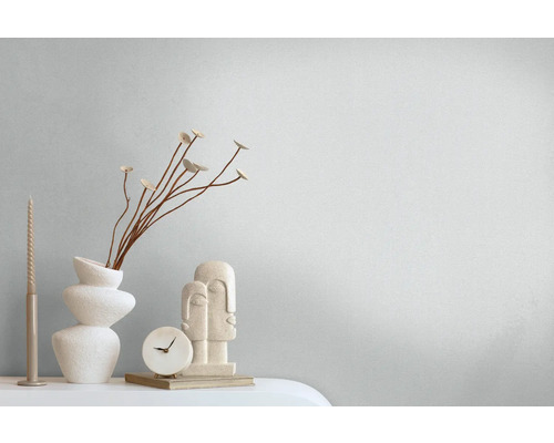 Dekorative Stilllebenanordnung mit Kerze, Vase, Dekoration, Uhr und Figuren.