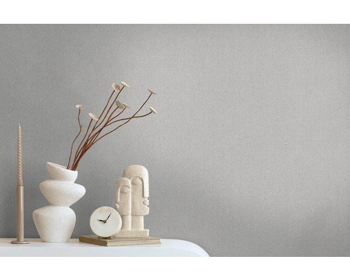 Nahaufnahme einer grauen Tapete mit Dekorationselementen wie einer Vase, einer Skulptur und einer Uhr