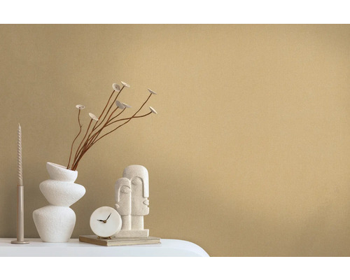 Dekorative Szene mit einer Vase, Zweigen, einer Kerze, einer Uhr und einer Skulptur auf einem Tisch.