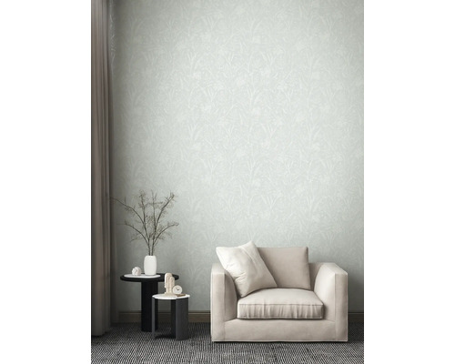 Wohnzimmer mit gemusterter Tapete, Sessel und Beistelltischen