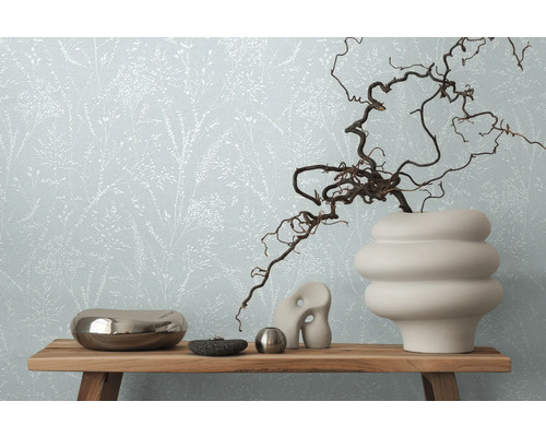 Wohnraum mit floral gemusterter Tapete und Dekorationen auf einem Holzregal